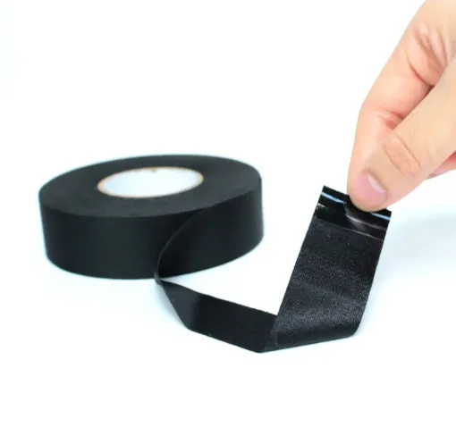 Close-up texture of PET cloth tape showing woven backing and adhesive layer for automotive wire harnesses”