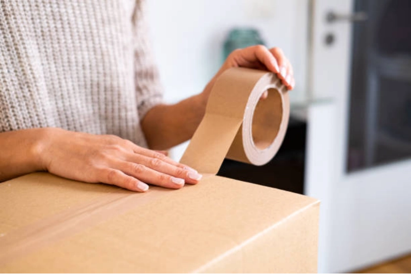 woman taping cardboard box